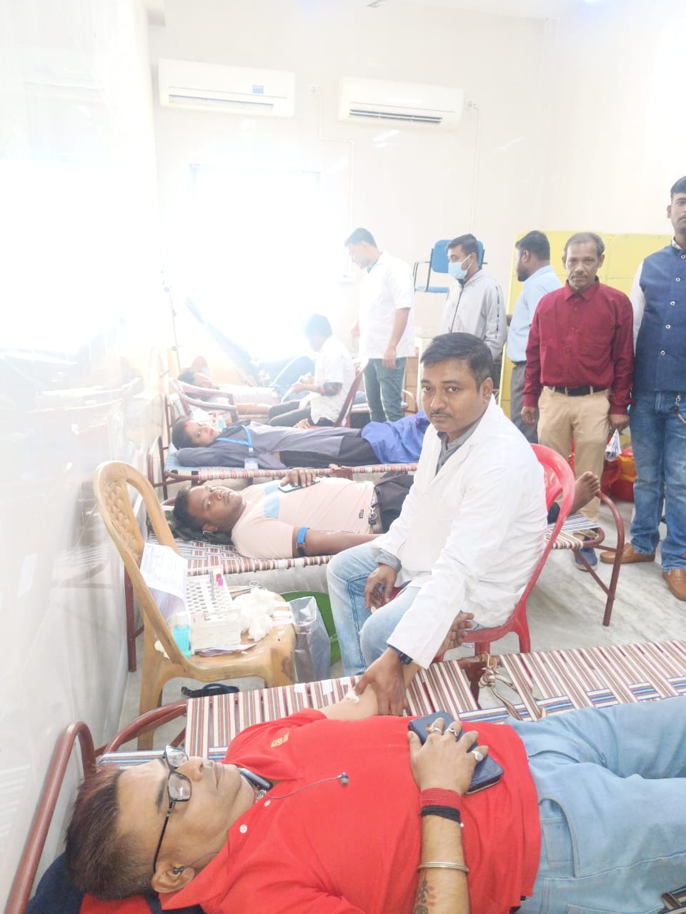 Volunteer settling in for the draw, team checking tube clamp and flow. — Kalyani blood donation camp