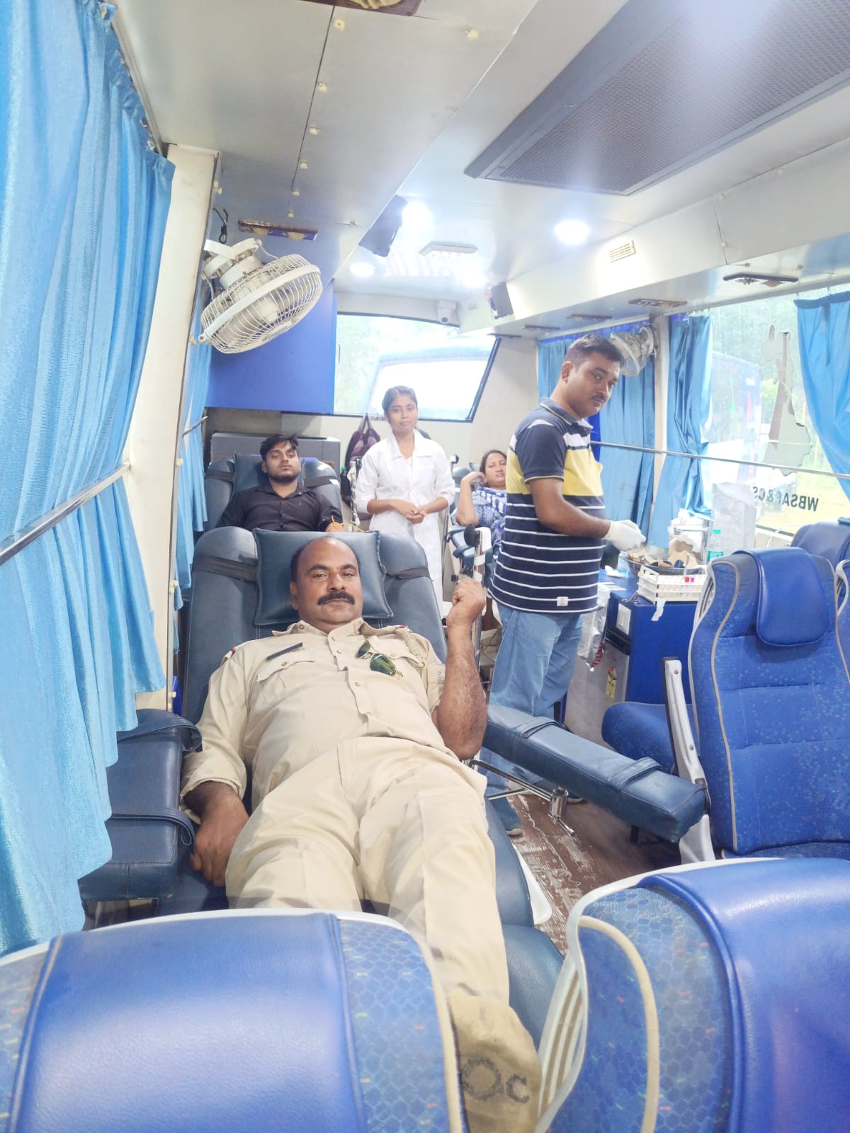 Volunteer settling in for the draw, team checking tube clamp and flow. — Aminpur blood donation camp