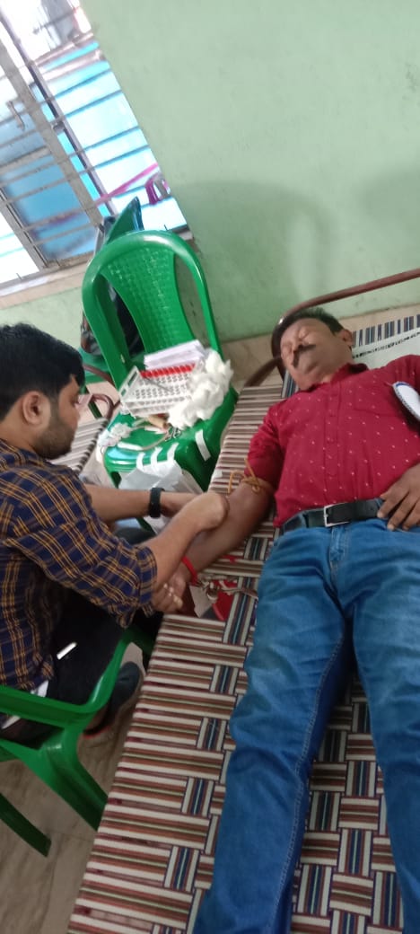 Donor giving a thumbs-up halfway through the pull. — Nilganj blood donation camp