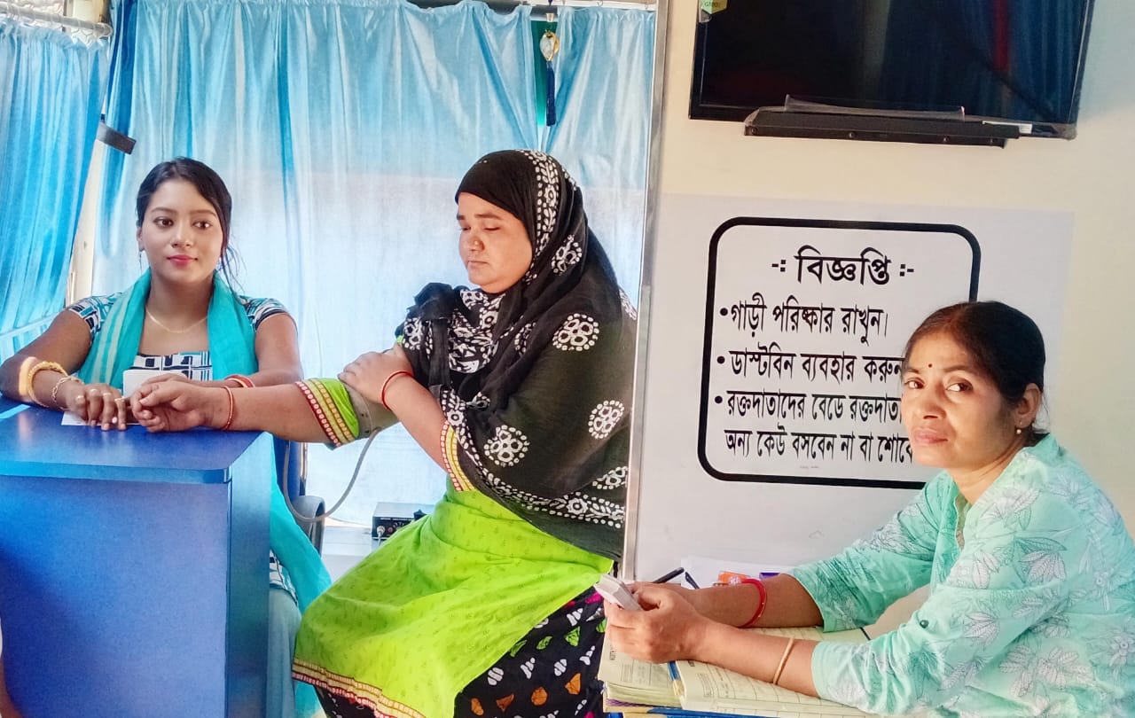 End of the bag — clamp going on, gauze ready, donor about to sit up. — Ghola blood donation camp