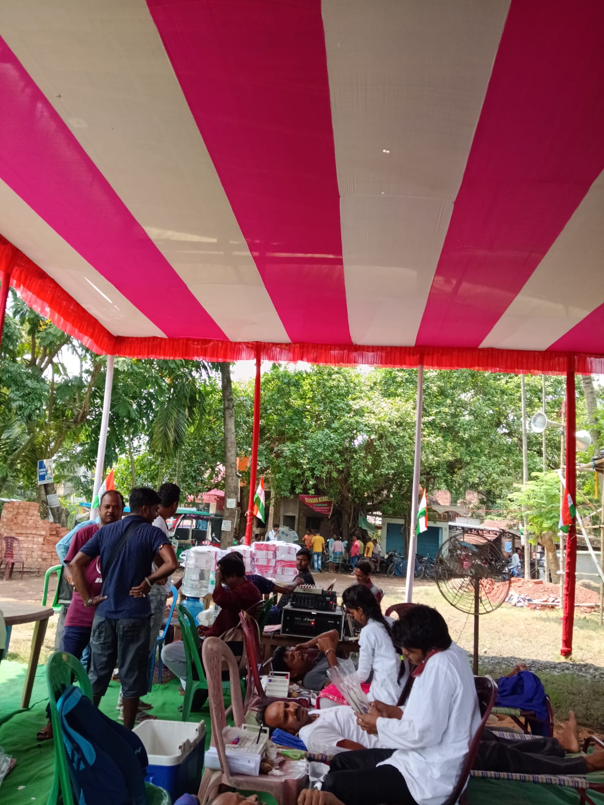 Team huddle before doors open — bed count, screening flow, who is at which station. — Ghola blood donation camp