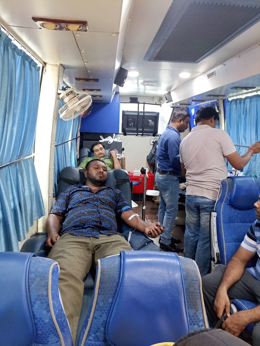 Mid-camp throughput: multiple beds running, attendants rotating. — Duttapukur blood donation camp