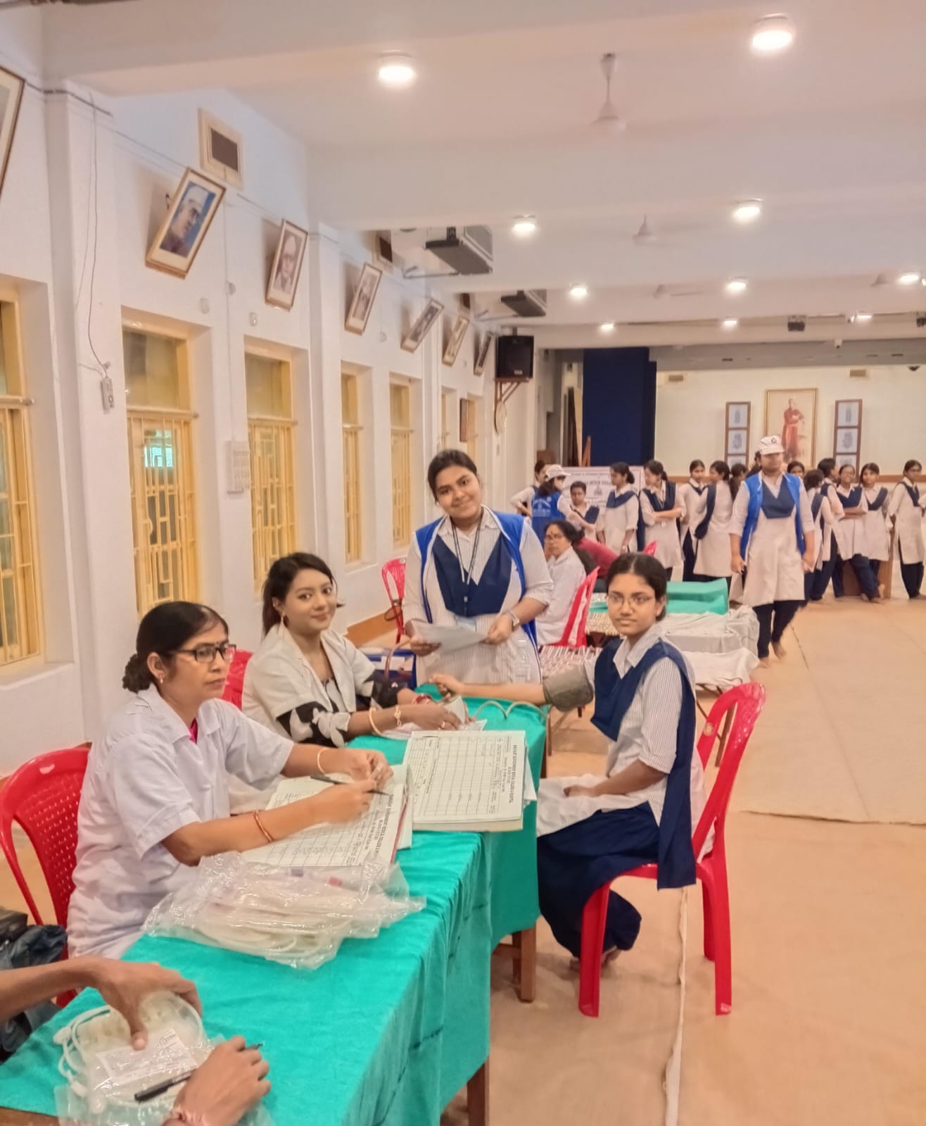 Registration desk at the front — donor cards being filled out as the queue builds. — Duttapukur blood donation camp