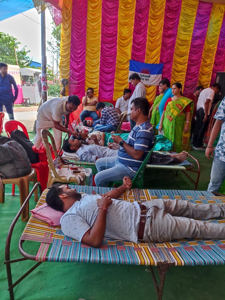Registration desk at the front — donor cards being filled out as the queue builds. — Hridaypur blood donation camp