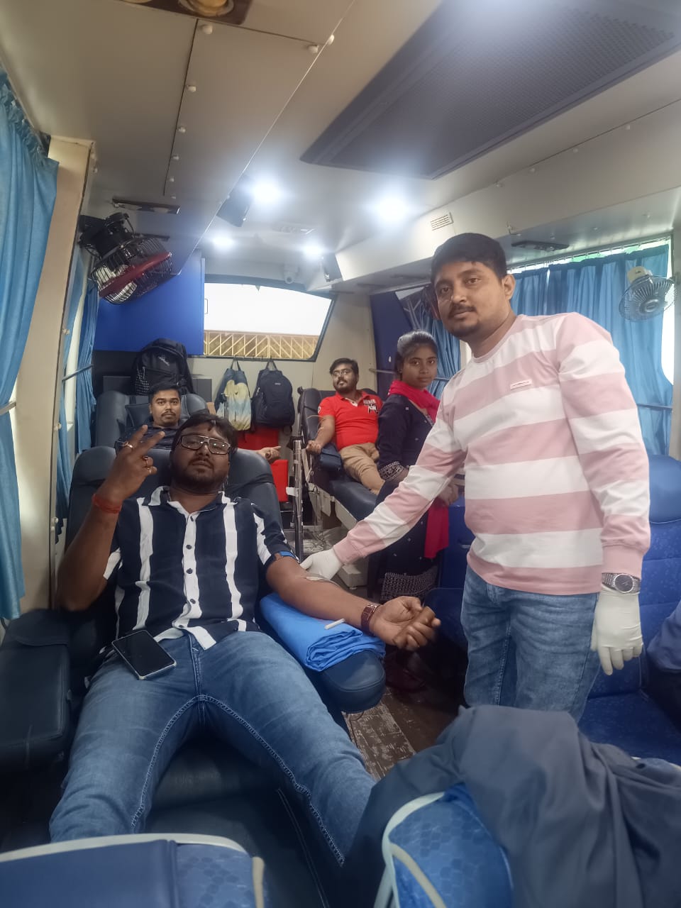 Registration desk at the front — donor cards being filled out as the queue builds. — Ranaghat blood donation camp