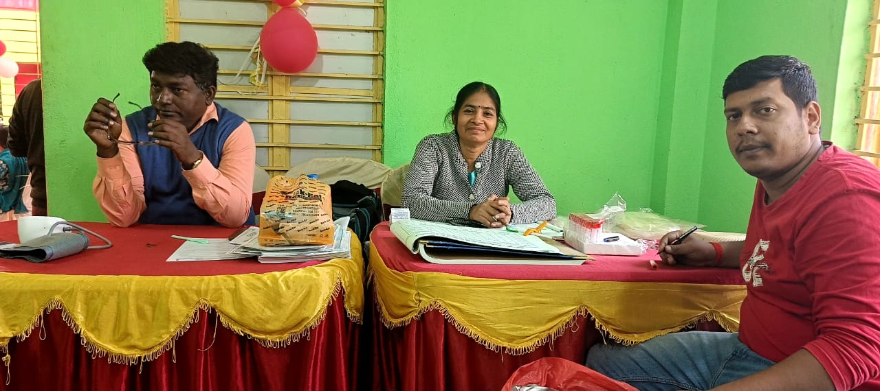 Mid-camp throughput: multiple beds running, attendants rotating. — Ranaghat blood donation camp