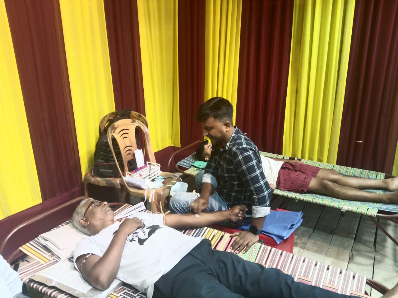 Anubhav CMC desk running back-to-back screenings — sugar, hemoglobin, BIA for every donor in queue. — Amdanga blood donation camp