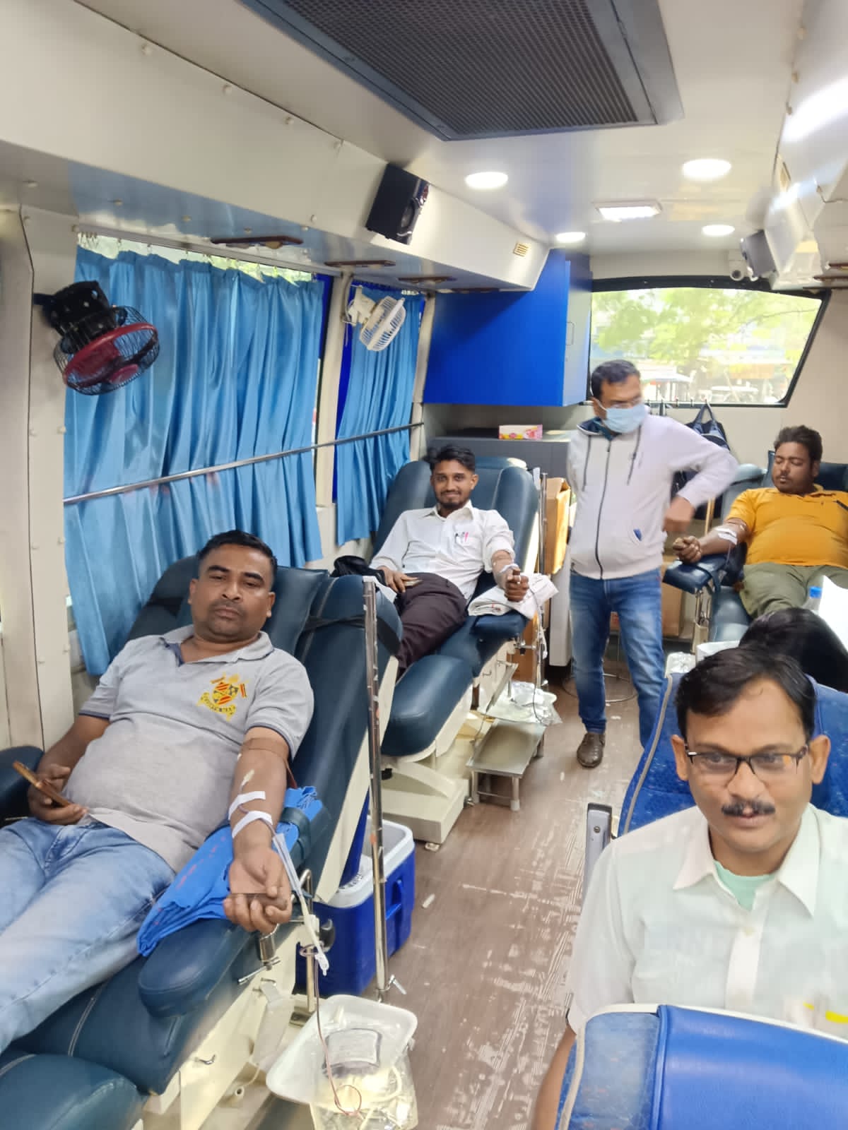 Donor on the bed mid-collection — vitals stable, conversation steady. — Chakla blood donation camp