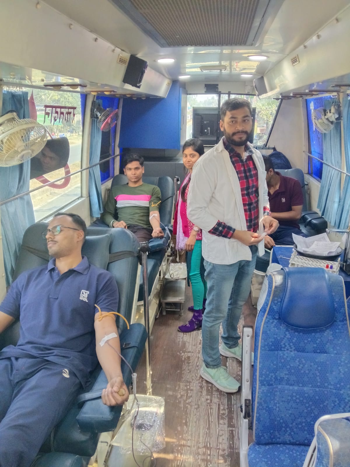 End of the bag — clamp going on, gauze ready, donor about to sit up. — Deganga blood donation camp