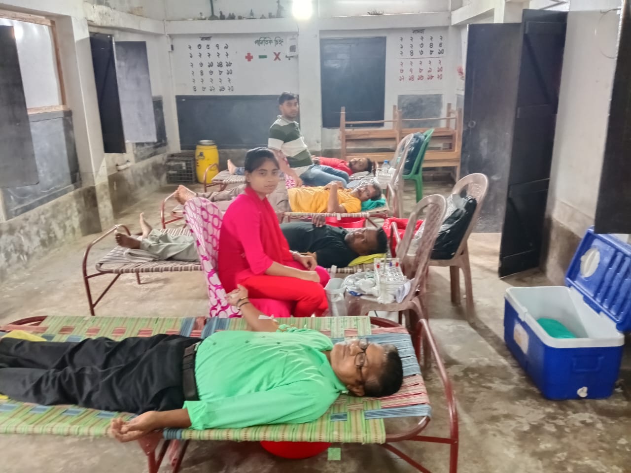 Pre-donation screening at the Anubhav CMC counter — fasting/random sugar from a single fingerprick. — Bira blood donation camp